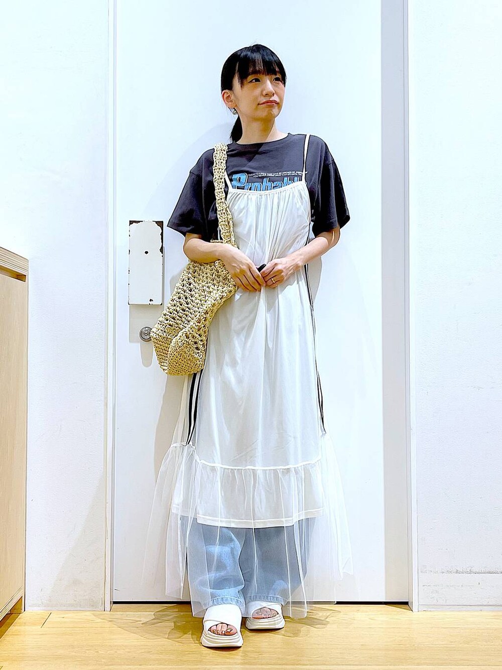 ホワイト系のサンダル、ブルー系のデニムパンツ、ホワイト系のトートバッグを着用したレディースの夏コーディネートの2枚目の写真