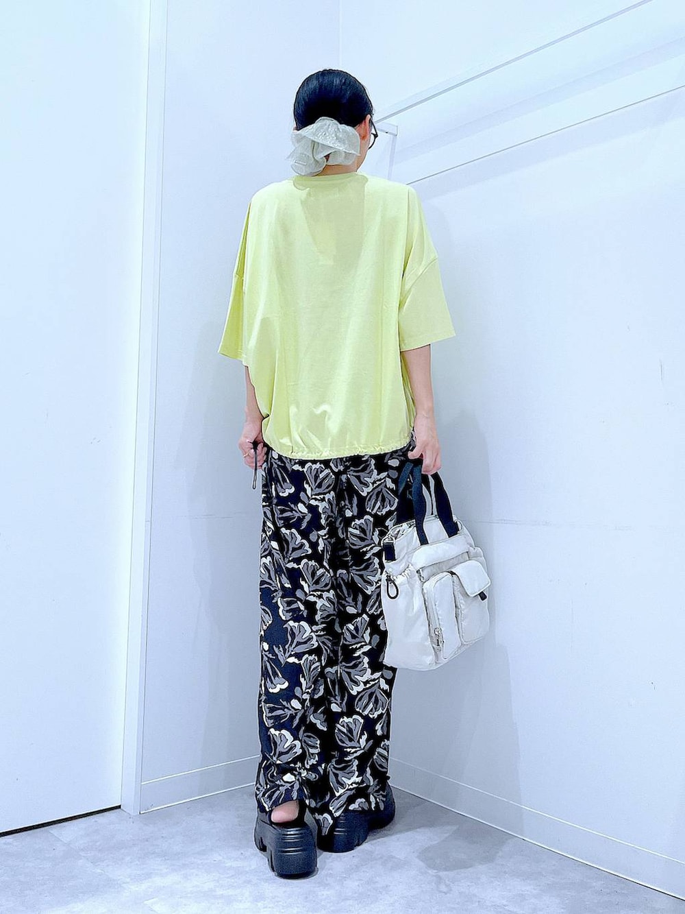 ブラック系のその他パンツ、グリーン系のTシャツ/カットソー、ホワイト系のトートバッグを着用したレディースの夏コーディネートの5枚目の写真