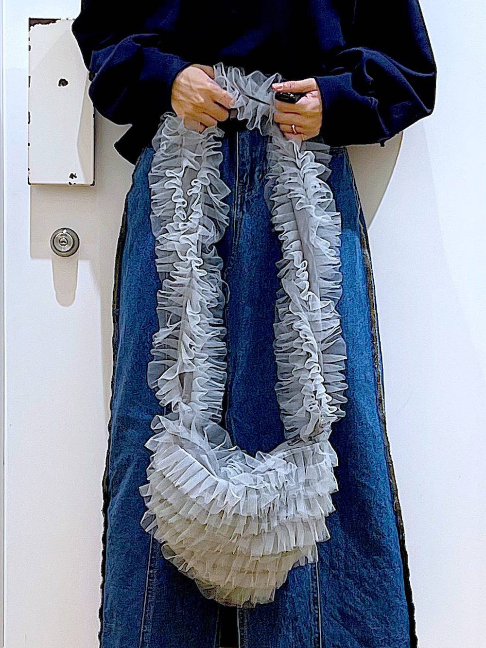 ブルー系のデニムスカート、ブラック系のブーツ、グレー系のショルダーバッグを着用したレディースの冬コーディネートの9枚目の写真