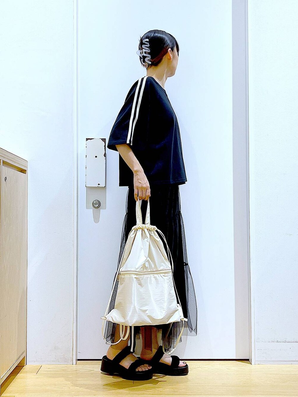 ホワイト系のバックパック/リュック、ブラック系のサンダル、ブラック系のスカートを着用したレディースの夏コーディネートの4枚目の写真