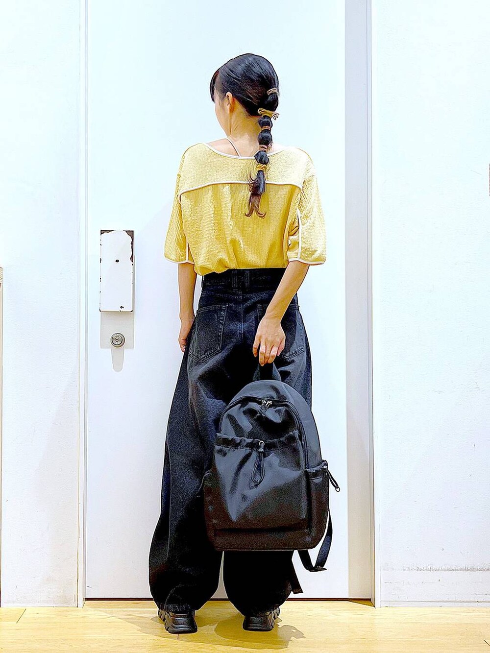 ブラック系のサンダル、ブラック系のバックパック/リュック、ブラック系のデニムパンツを着用したレディースの夏コーディネートの5枚目の写真