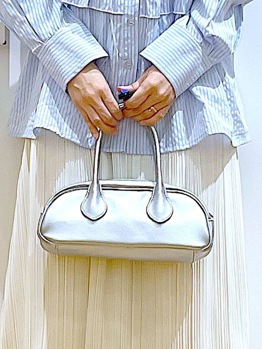 シルバー系のボストンバッグ、シルバー系のパンプス、ブルー系のシャツ/ブラウスを着用したレディースの春コーディネートの9枚目の写真