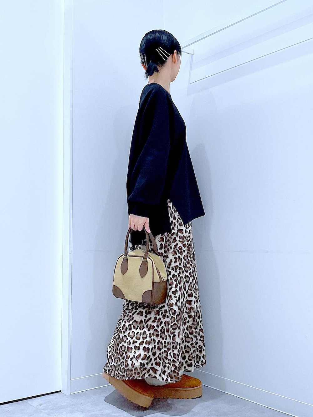 イエロー系のスリッポン、ベージュ系のハンドバッグ、ブラウン系のスカートを着用したレディースの秋コーディネートの4枚目の写真