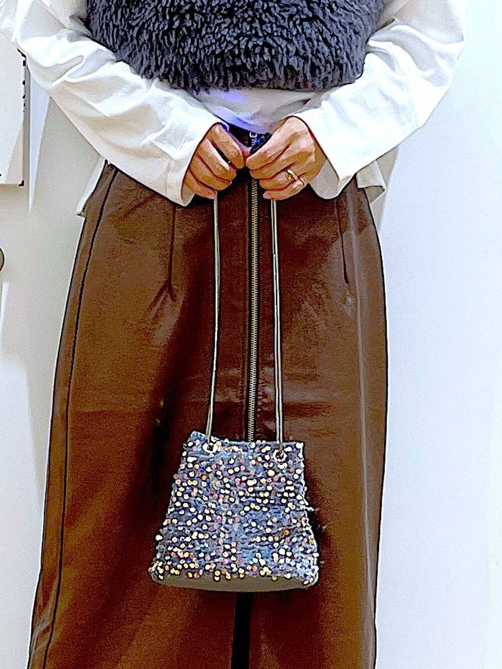 ブラウン系のスカート、グレー系のベスト、ブラック系のローファーを着用したレディースの秋コーディネートの9枚目の写真