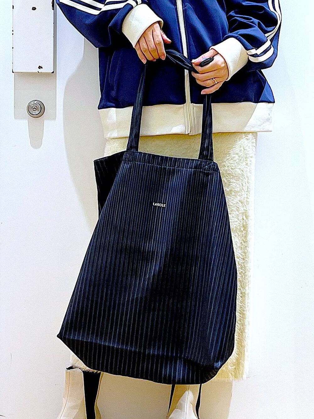 ベージュ系のブーツ、ブルー系のトートバッグ、ブルー系のスウェットを着用したレディースの冬コーディネートの9枚目の写真