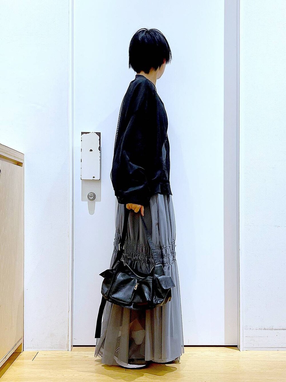 ブラック系のショルダーバッグ、ブラック系のブルゾン、ブルー系のTシャツ/カットソーを着用したレディースの春コーディネートの4枚目の写真