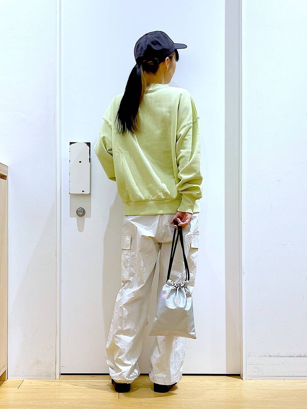 イエロー系のスウェット、ベージュ系のブーツ、その他のショルダーバッグを着用したレディースの春コーディネートの5枚目の写真