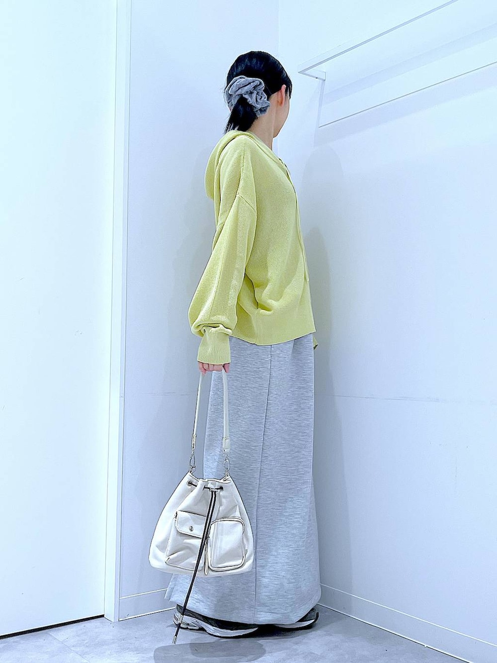 ベージュ系のショルダーバッグ、グレー系のスカート、イエロー系のカーディガン/ボレロを着用したレディースの春コーディネートの4枚目の写真
