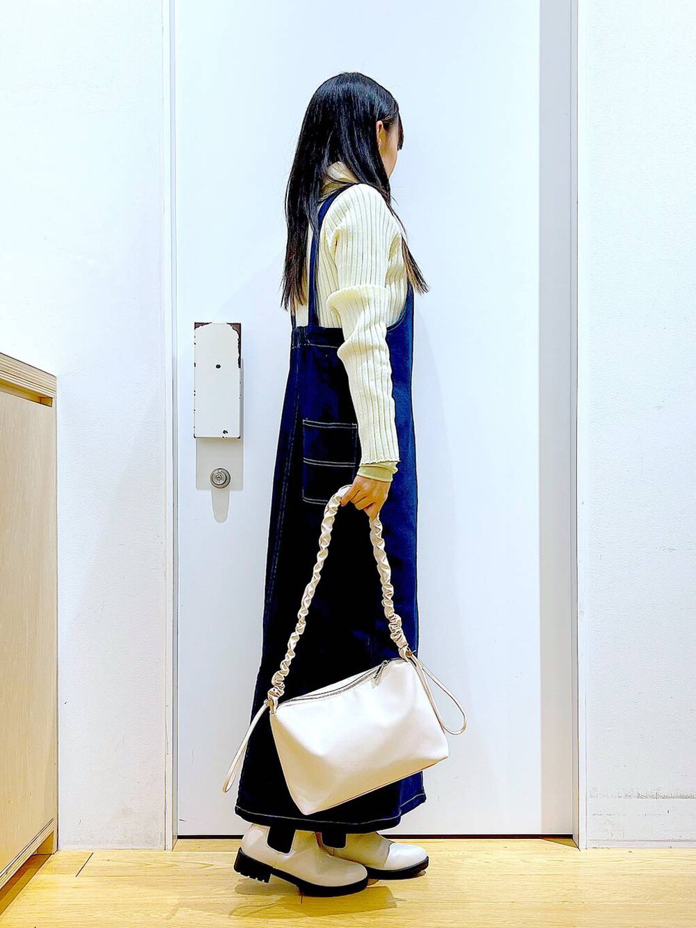 ブルー系のジャンパースカート、ベージュ系のカーディガン/ボレロ、グリーン系のその他トップスを着用したレディースの春コーディネートの4枚目の写真