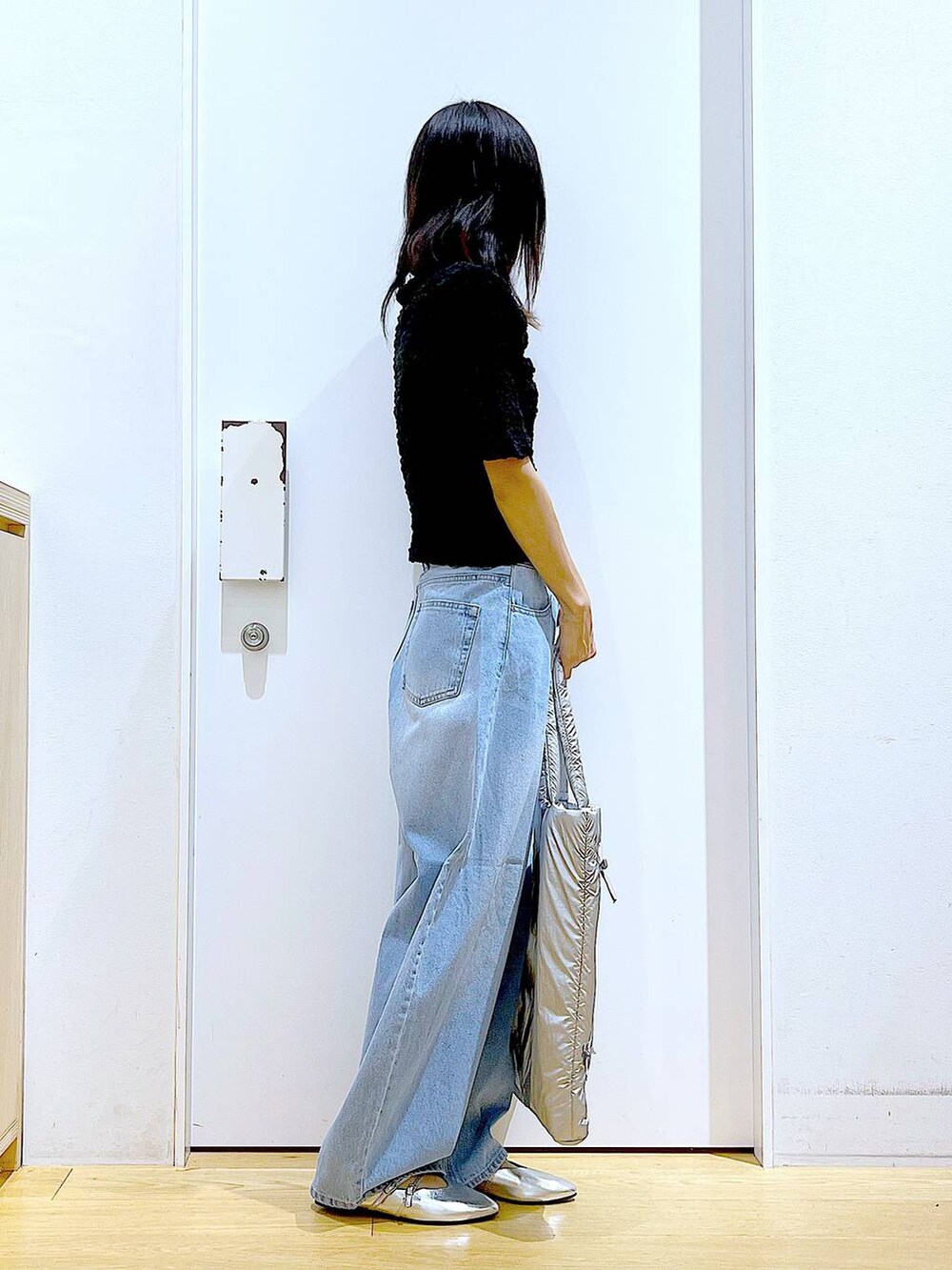 ブラック系のカーディガン/ボレロ、シルバー系のトートバッグ、ブルー系のデニムパンツを着用したレディースの秋コーディネートの4枚目の写真