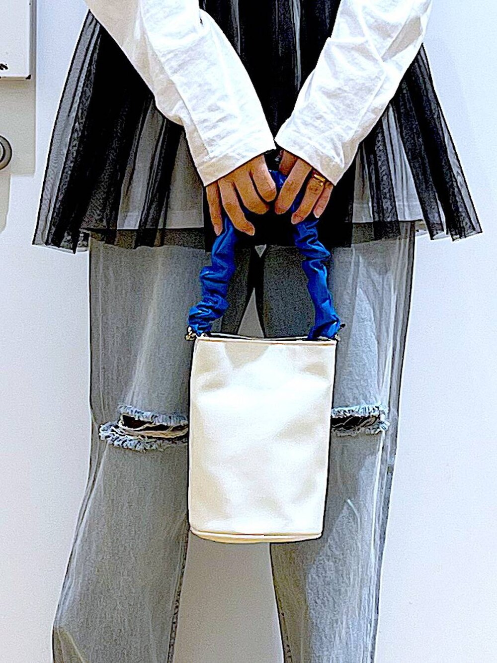 ブルー系のショルダーバッグ、ブラック系のキャミソール、ブルー系のデニムパンツを着用したレディースの春コーディネートの9枚目の写真