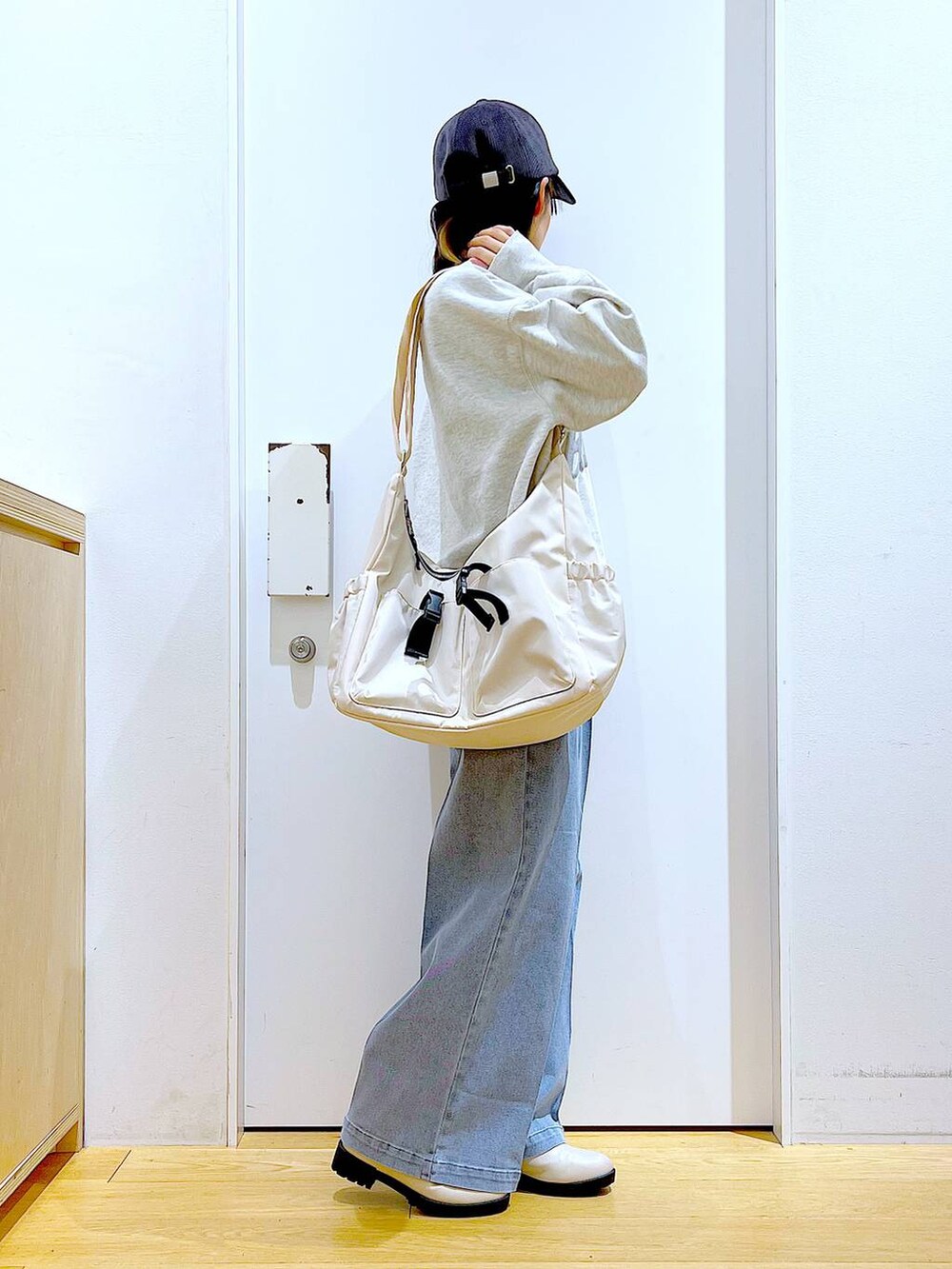 ブルー系のデニムパンツ、ベージュ系のスウェット、ベージュ系のブーツを着用したレディースの冬コーディネートの4枚目の写真