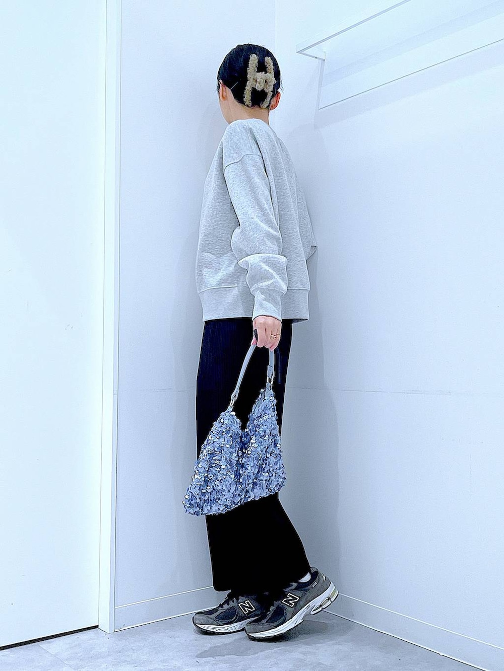 グレー系のカーディガン/ボレロ、ブルー系のショルダーバッグ、ブラック系のスカートを着用したレディースの春コーディネートの3枚目の写真