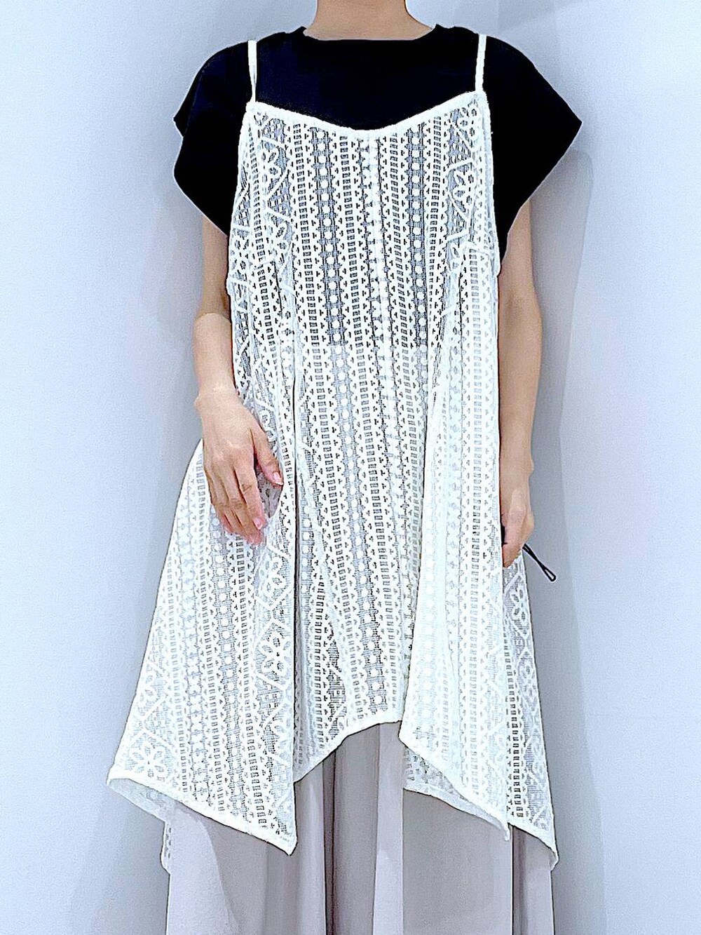 ホワイト系のショルダーバッグ、ホワイト系のサンダル、ブラック系のTシャツ/カットソーを着用したレディースの夏コーディネートの7枚目の写真