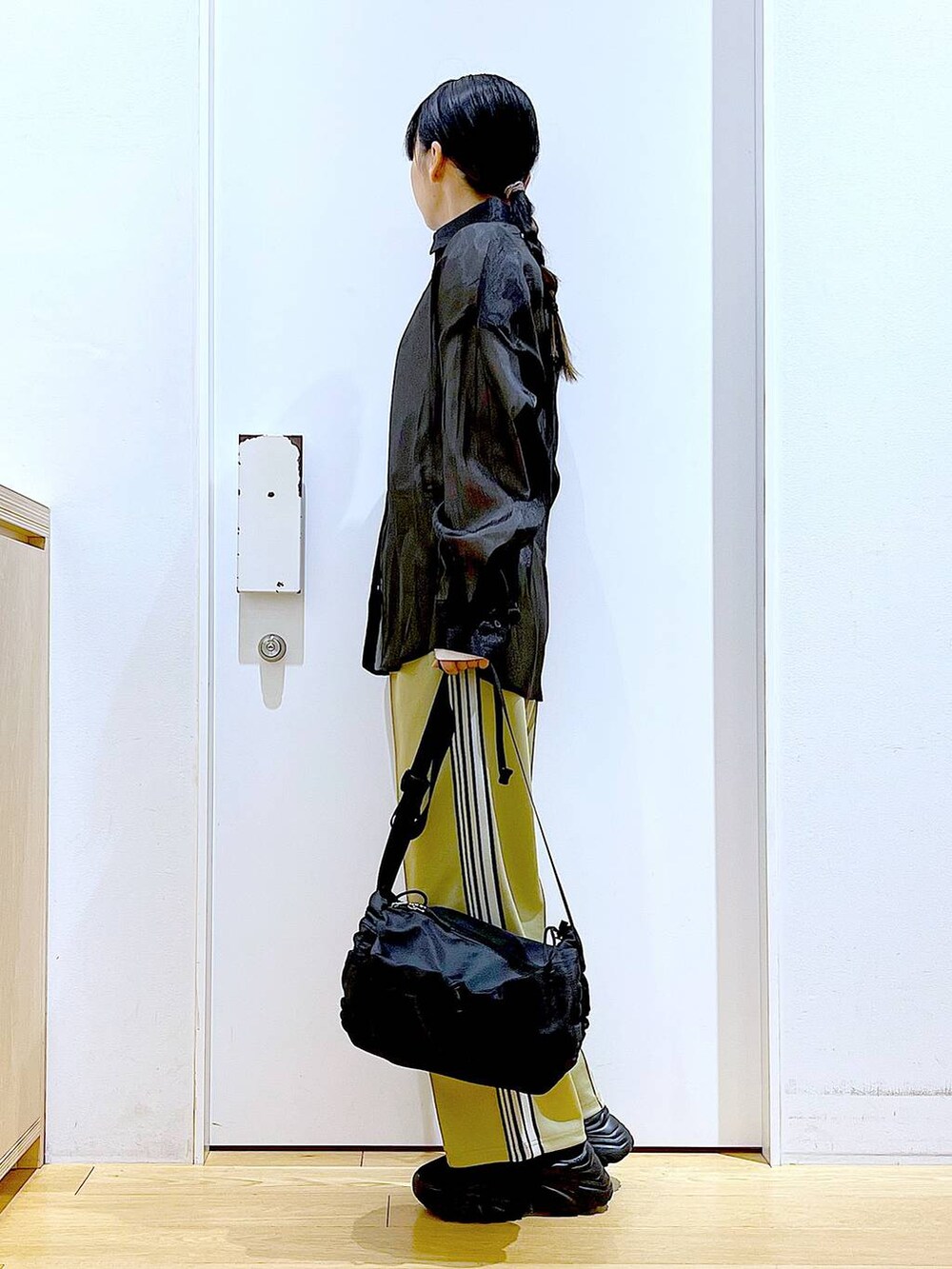 グリーン系のその他パンツ、ブラック系のスニーカー、ブラック系のショルダーバッグを着用したレディースの春コーディネートの3枚目の写真