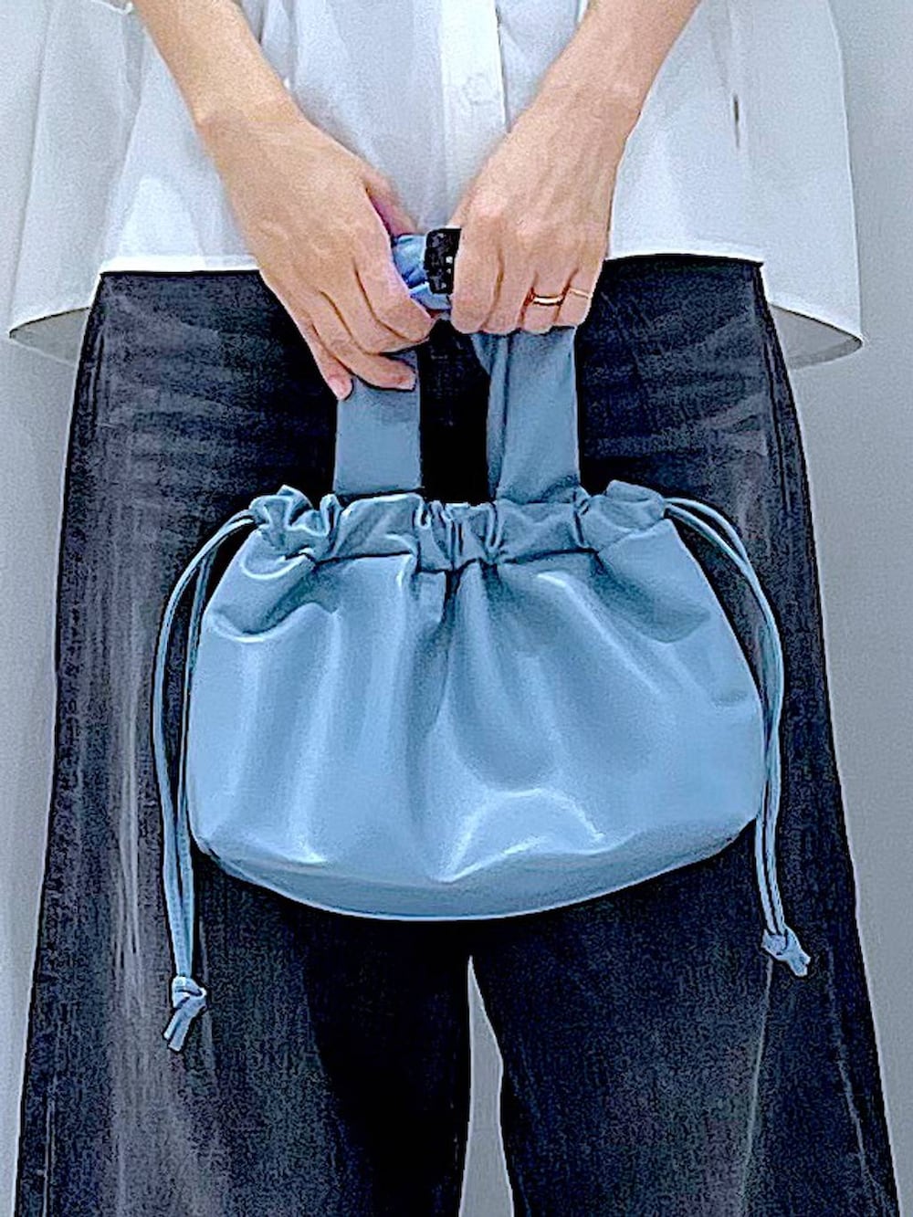 ブラック系のデニムパンツ、ブラック系のスニーカー、ブルー系のショルダーバッグを着用したレディースの夏コーディネートの9枚目の写真