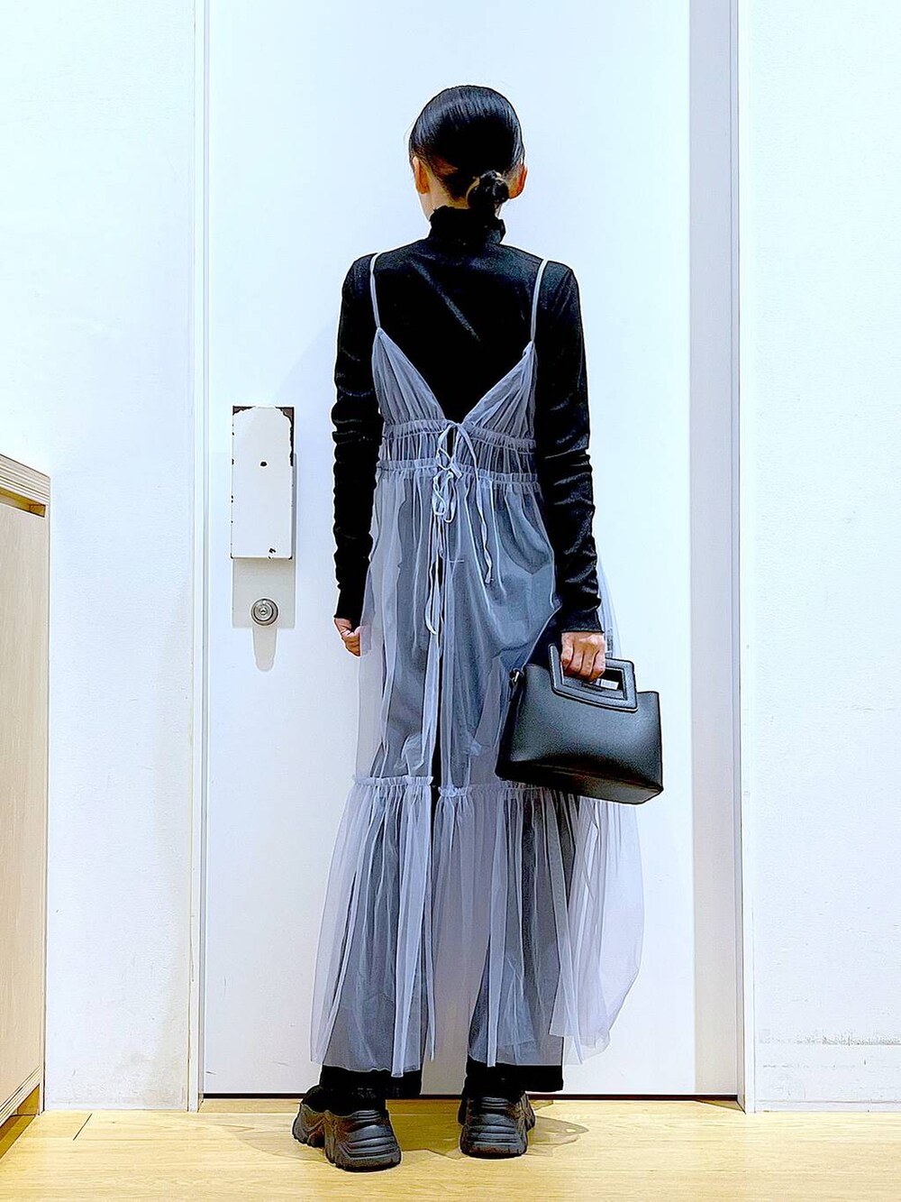 グレー系のデニムパンツ、ブルー系のワンピース、ブラック系のTシャツ/カットソーを着用したレディースの春コーディネートの5枚目の写真