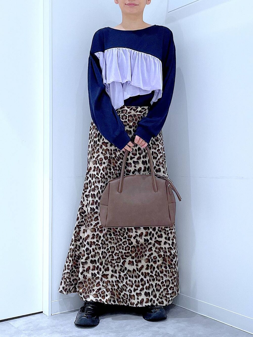 ブラック系のローファー、ブラウン系のボストンバッグ、ブラウン系のスカートを着用したレディースの秋コーディネートの6枚目の写真