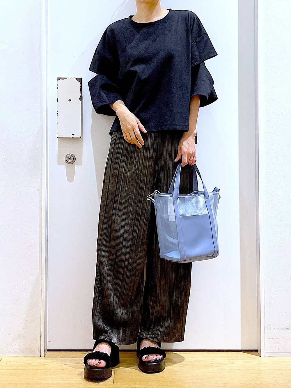 ブラック系のサンダル、ブルー系のトートバッグ、ブラック系のTシャツ/カットソーを着用したレディースの秋コーディネートの6枚目の写真
