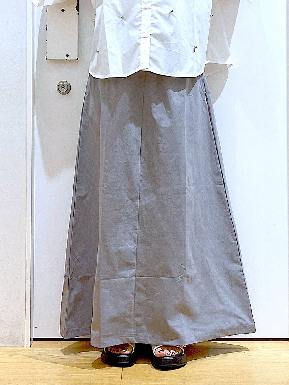 ホワイト系のサンダル、ホワイト系のショルダーバッグ、グレー系のスカートを着用したレディースの夏コーディネートの8枚目の写真