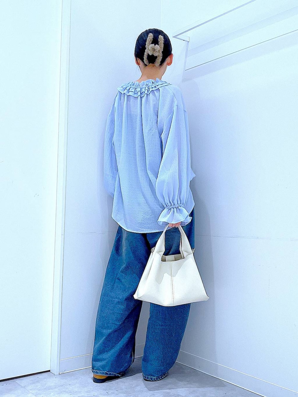 ブルー系のデニムパンツ、ベージュ系のローファー、ホワイト系のトートバッグを着用したレディースの春コーディネートの5枚目の写真