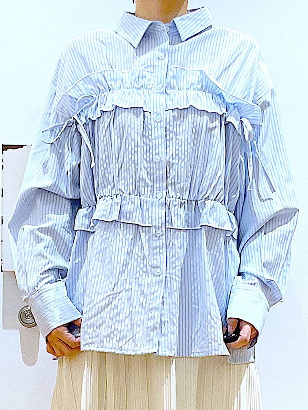シルバー系のボストンバッグ、シルバー系のパンプス、ブルー系のシャツ/ブラウスを着用したレディースの春コーディネートの7枚目の写真