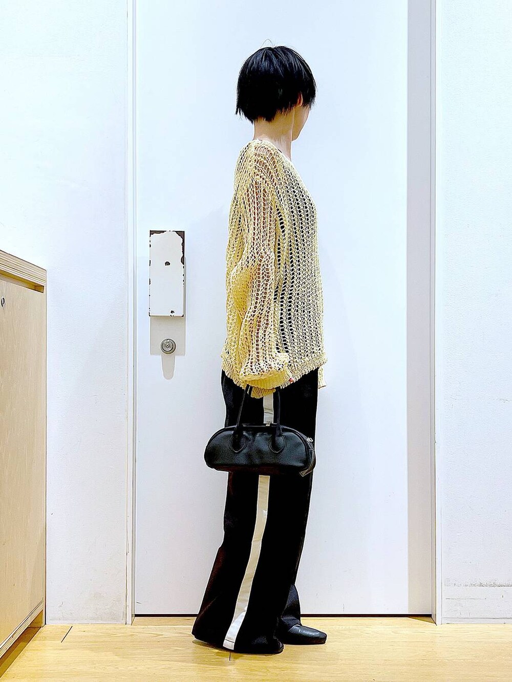 ブラック系のスラックス、ブラック系のボストンバッグ、ブラック系のパンプスを着用したレディースの夏コーディネートの4枚目の写真