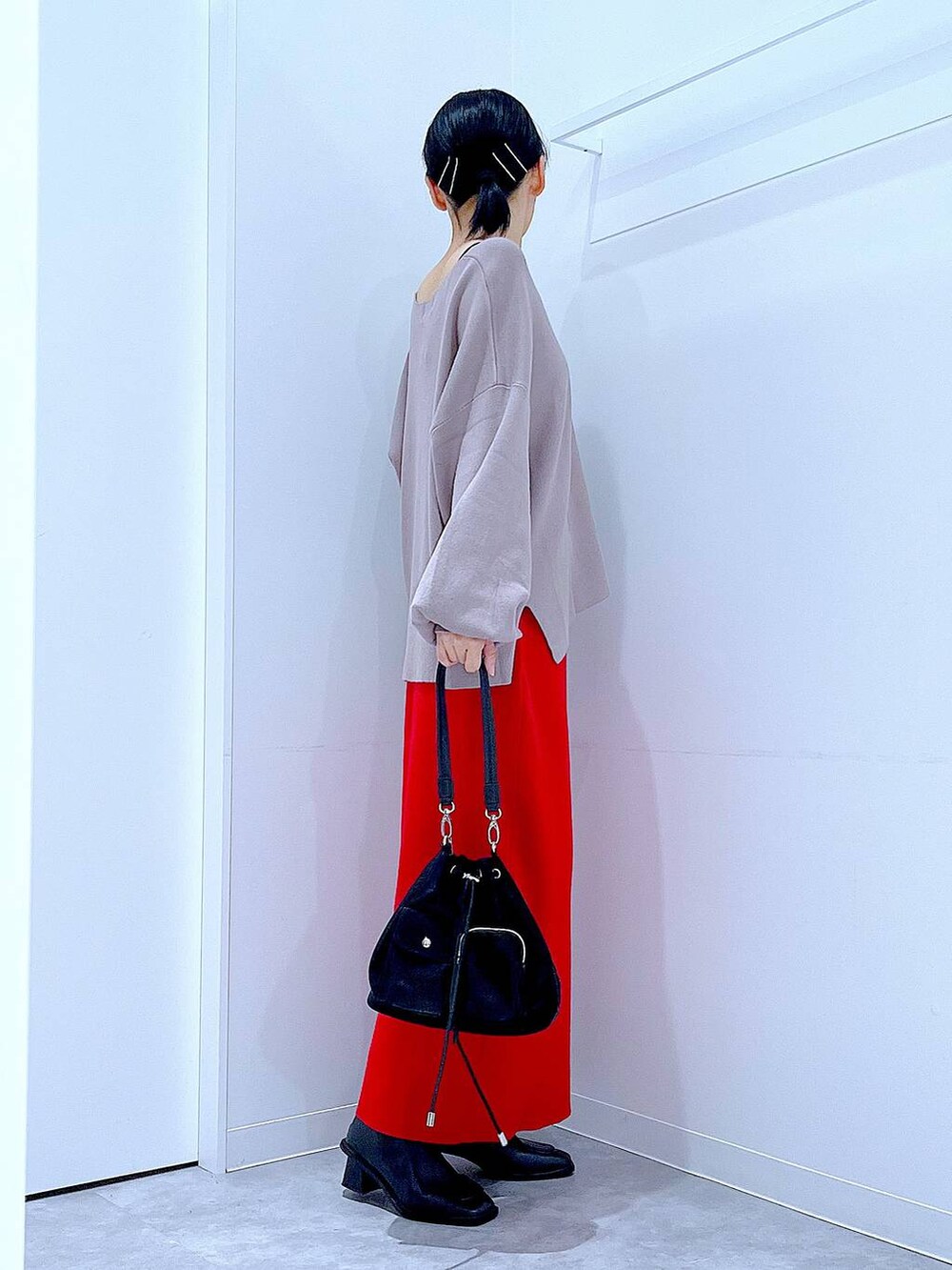 ブラウン系のニット/セーター、ブラック系のショルダーバッグ、ブラック系のブーツを着用したレディースの冬コーディネートの4枚目の写真