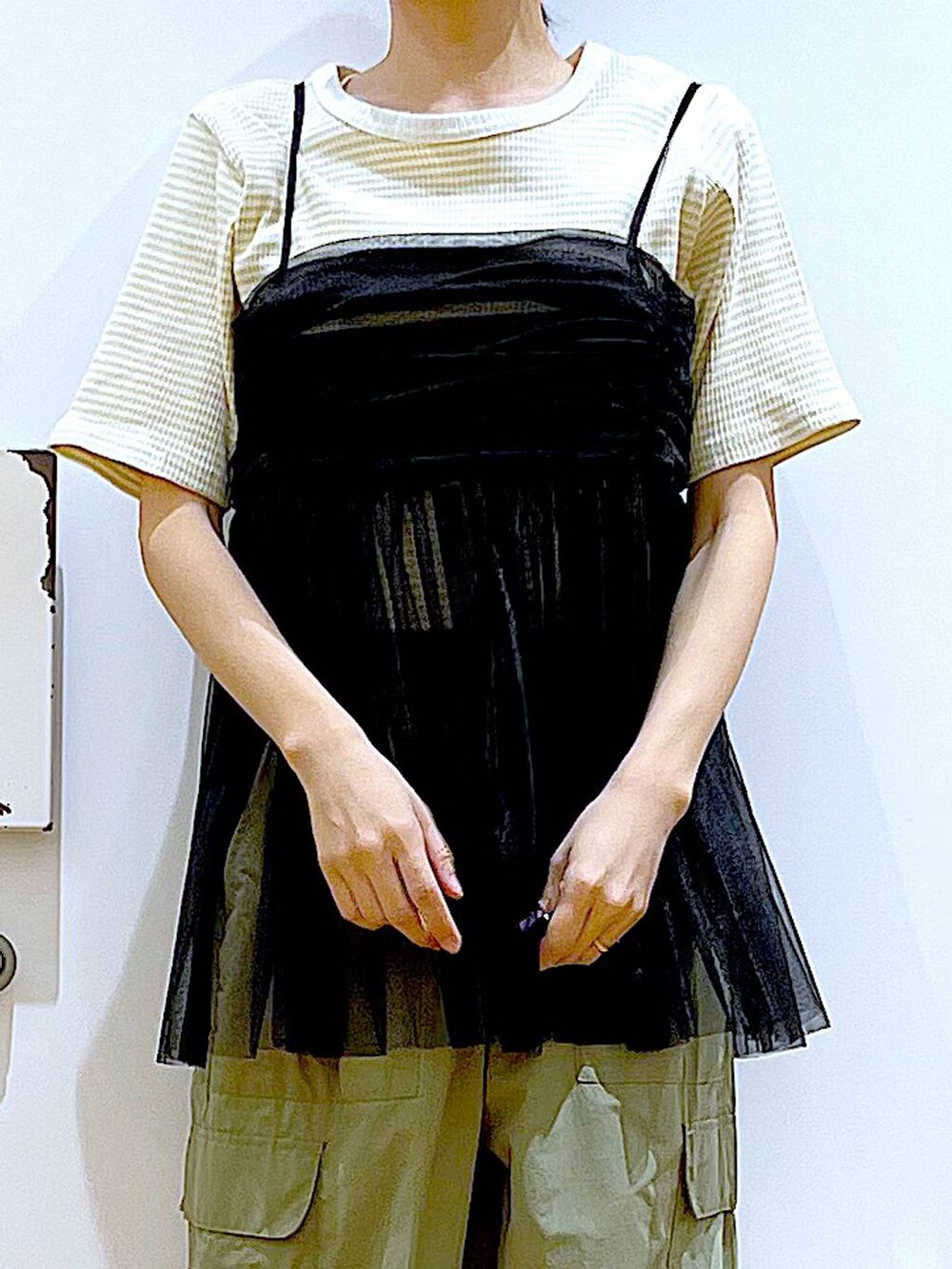 グリーン系のカーゴパンツ、ブラック系のキャミソール、その他のトートバッグを着用したレディースの夏コーディネートの7枚目の写真