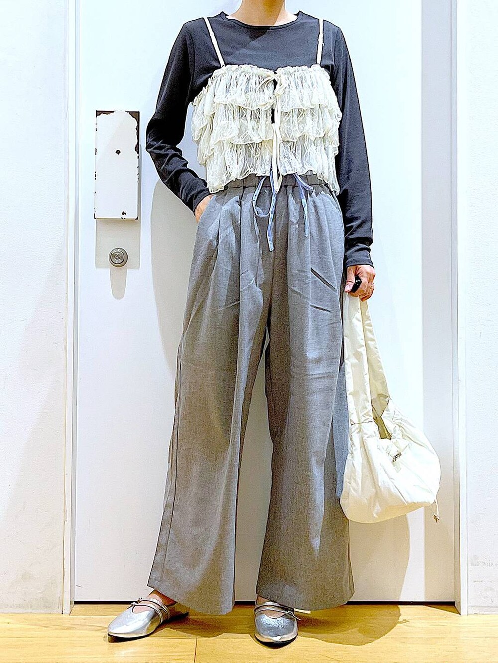 ホワイト系のハンドバッグ、シルバー系のパンプス、グレー系のTシャツ/カットソーを着用したレディースの秋コーディネートの6枚目の写真