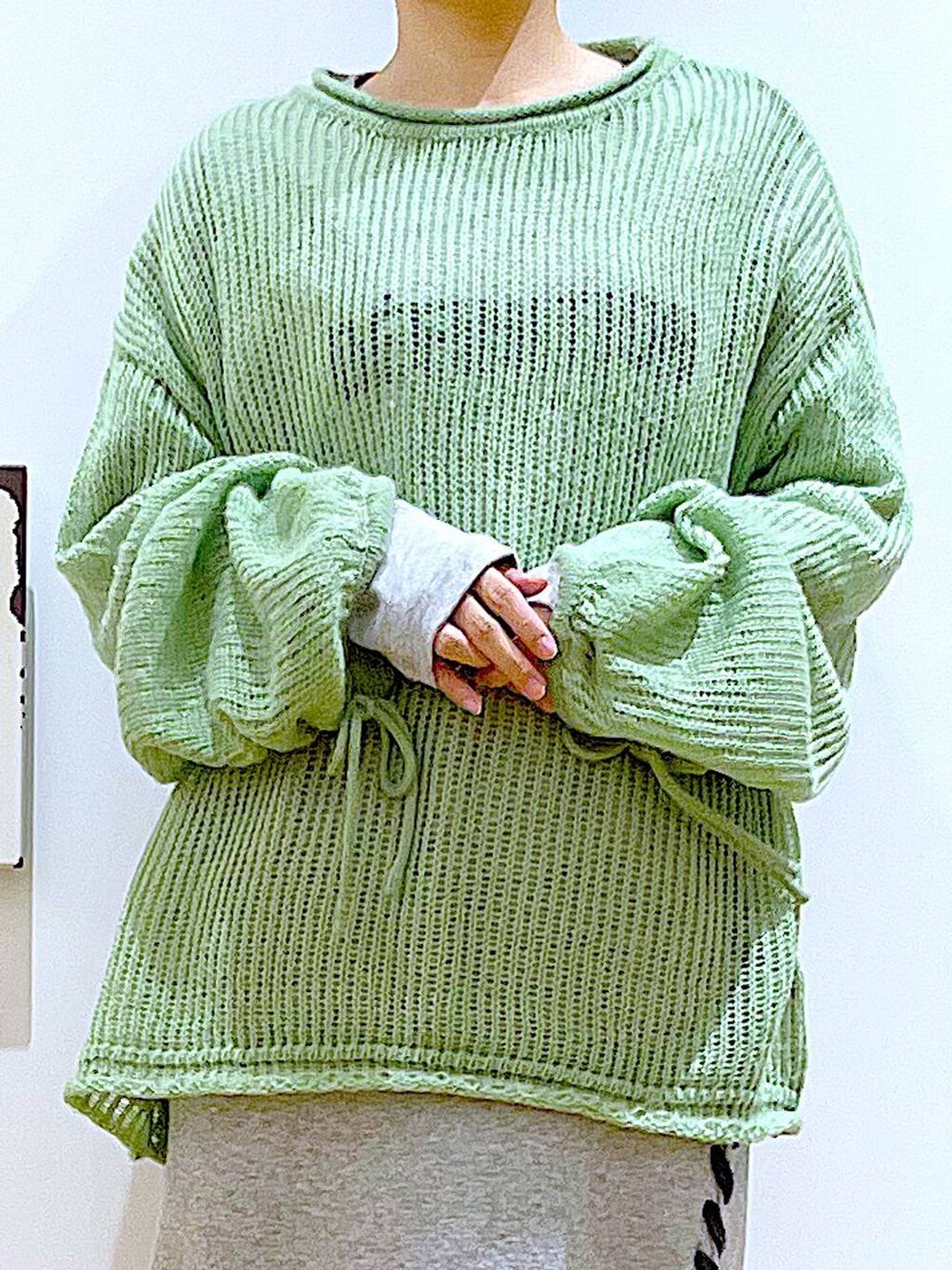 ブラック系のブーツ、グリーン系のニット/セーター、グレー系のスカートを着用したレディースの冬コーディネートの7枚目の写真