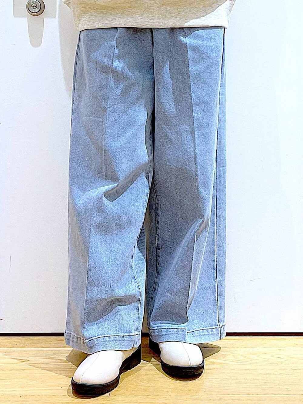 ブルー系のデニムパンツ、ベージュ系のスウェット、ベージュ系のブーツを着用したレディースの冬コーディネートの8枚目の写真