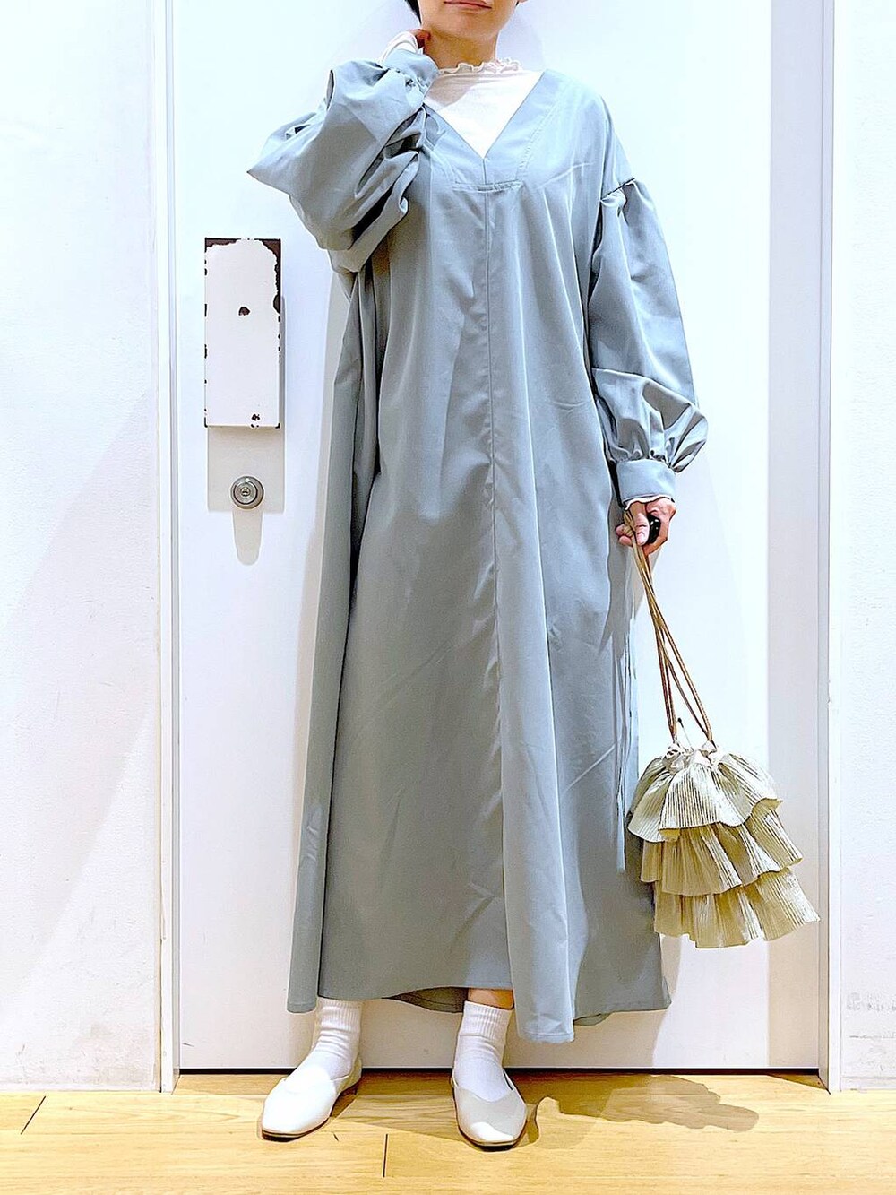 ベージュ系のTシャツ/カットソー、ホワイト系のパンプス、ベージュ系のショルダーバッグを着用したレディースの春コーディネートの6枚目の写真