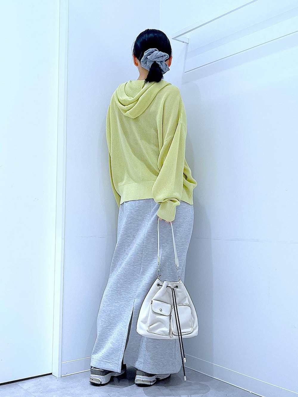 ベージュ系のショルダーバッグ、グレー系のスカート、イエロー系のカーディガン/ボレロを着用したレディースの春コーディネートの5枚目の写真