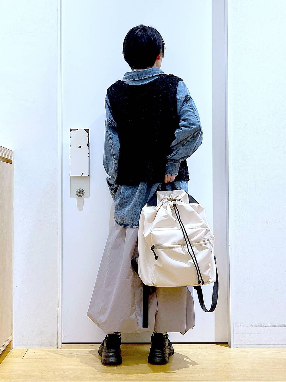 ブルー系のシャツ/ブラウス、ブラック系のスニーカー、ホワイト系のバックパック/リュックを着用したレディースの春コーディネートの5枚目の写真