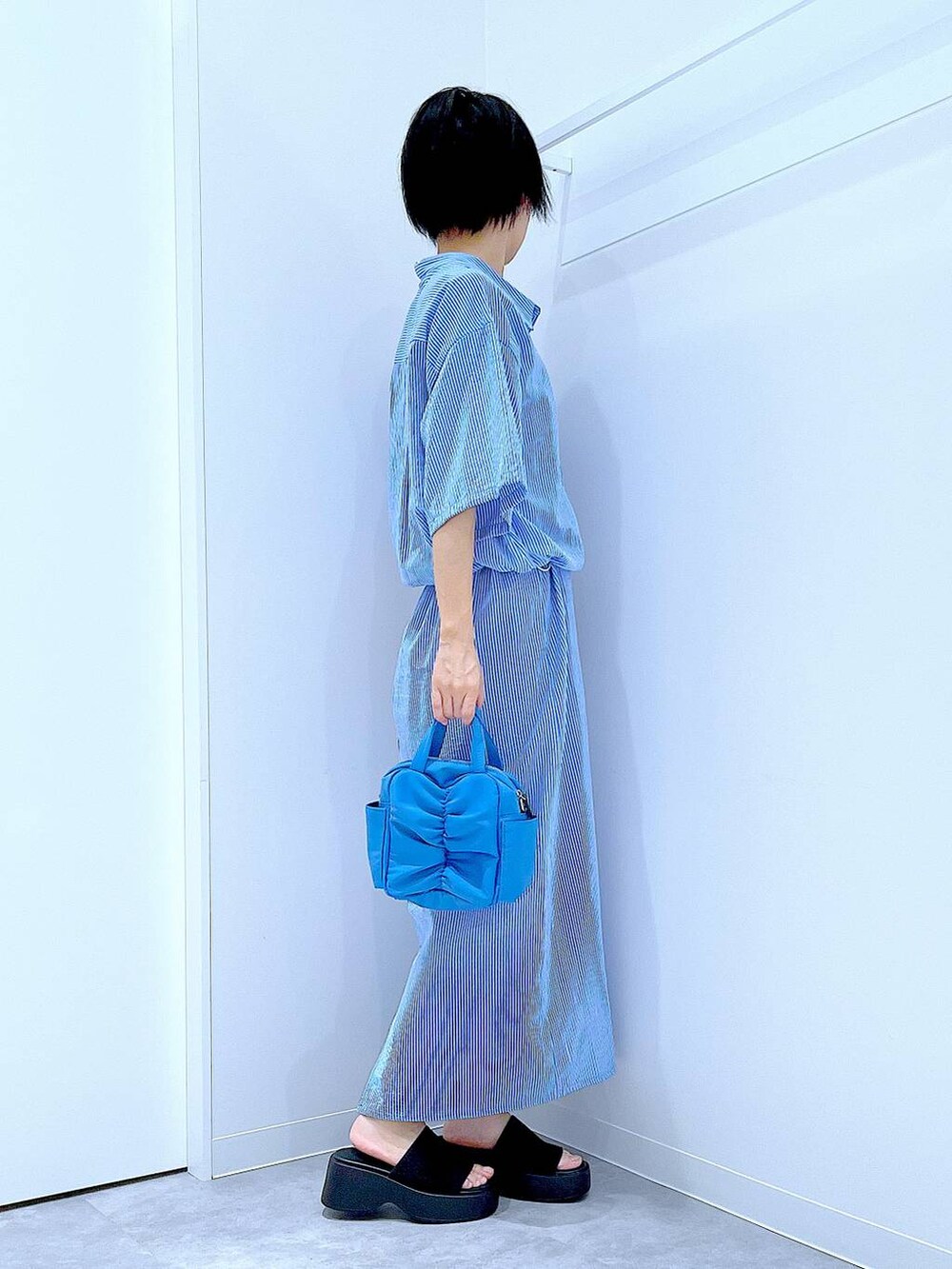 ブラック系のサンダル、ブルー系のワンピースを着用したレディースの夏コーディネートの4枚目の写真