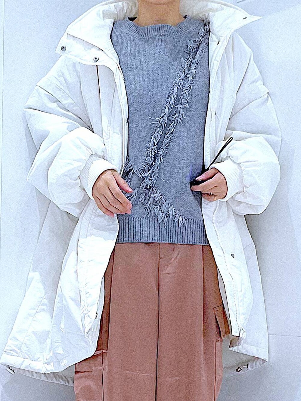 ホワイト系のブルゾン、ブラック系のショルダーバッグ、ブラック系のブーツを着用したレディースの冬コーディネートの7枚目の写真