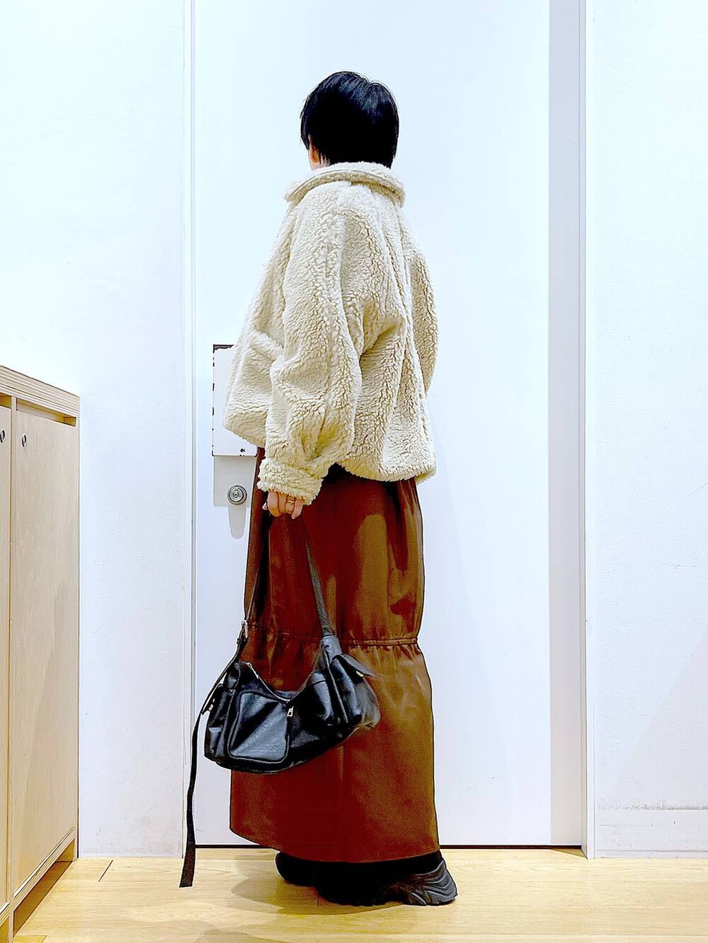 ホワイト系のブルゾン、ホワイト系のスウェット、ブラック系のブーツを着用したレディースの冬コーディネートの3枚目の写真