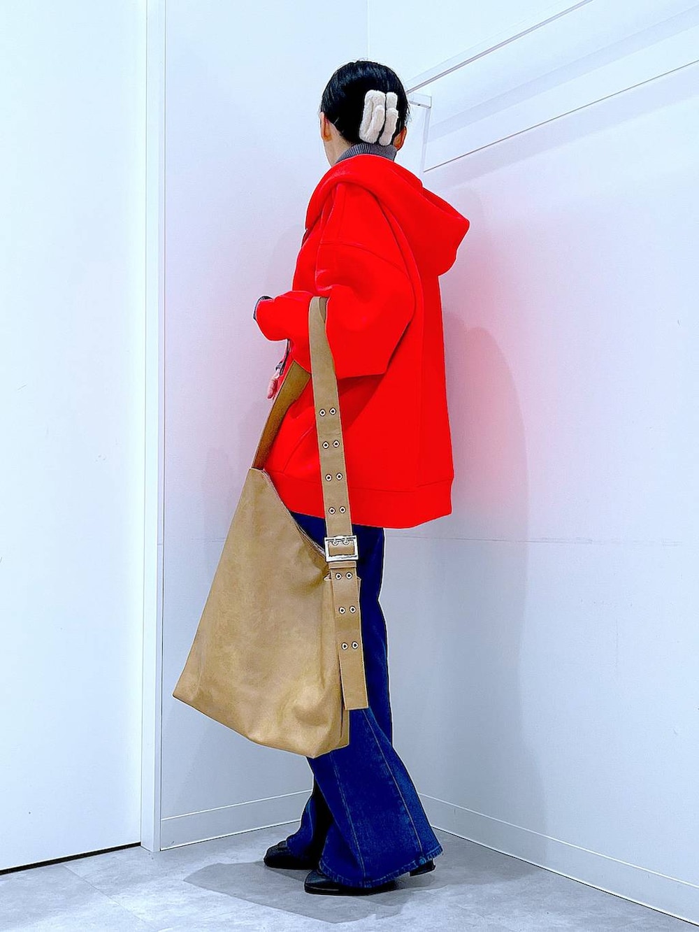 レッド系のパーカー、ブラック系のブーツ、グレー系のニット/セーターを着用したレディースの冬コーディネートの3枚目の写真