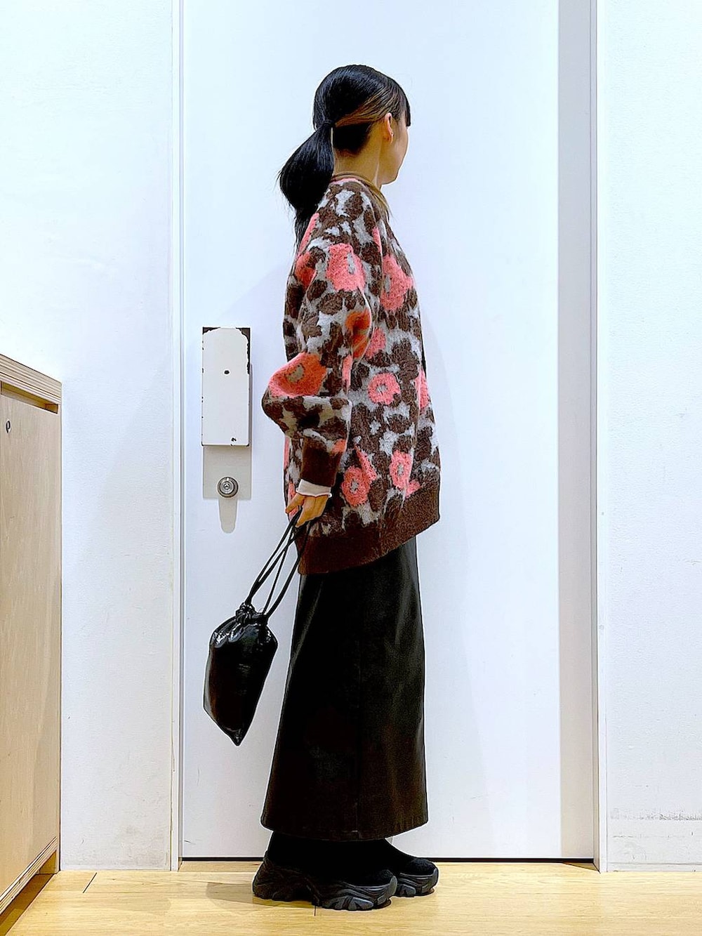 グレー系のTシャツ/カットソー、ブラック系のブーツ、ブラック系のスカートを着用したレディースの冬コーディネートの4枚目の写真