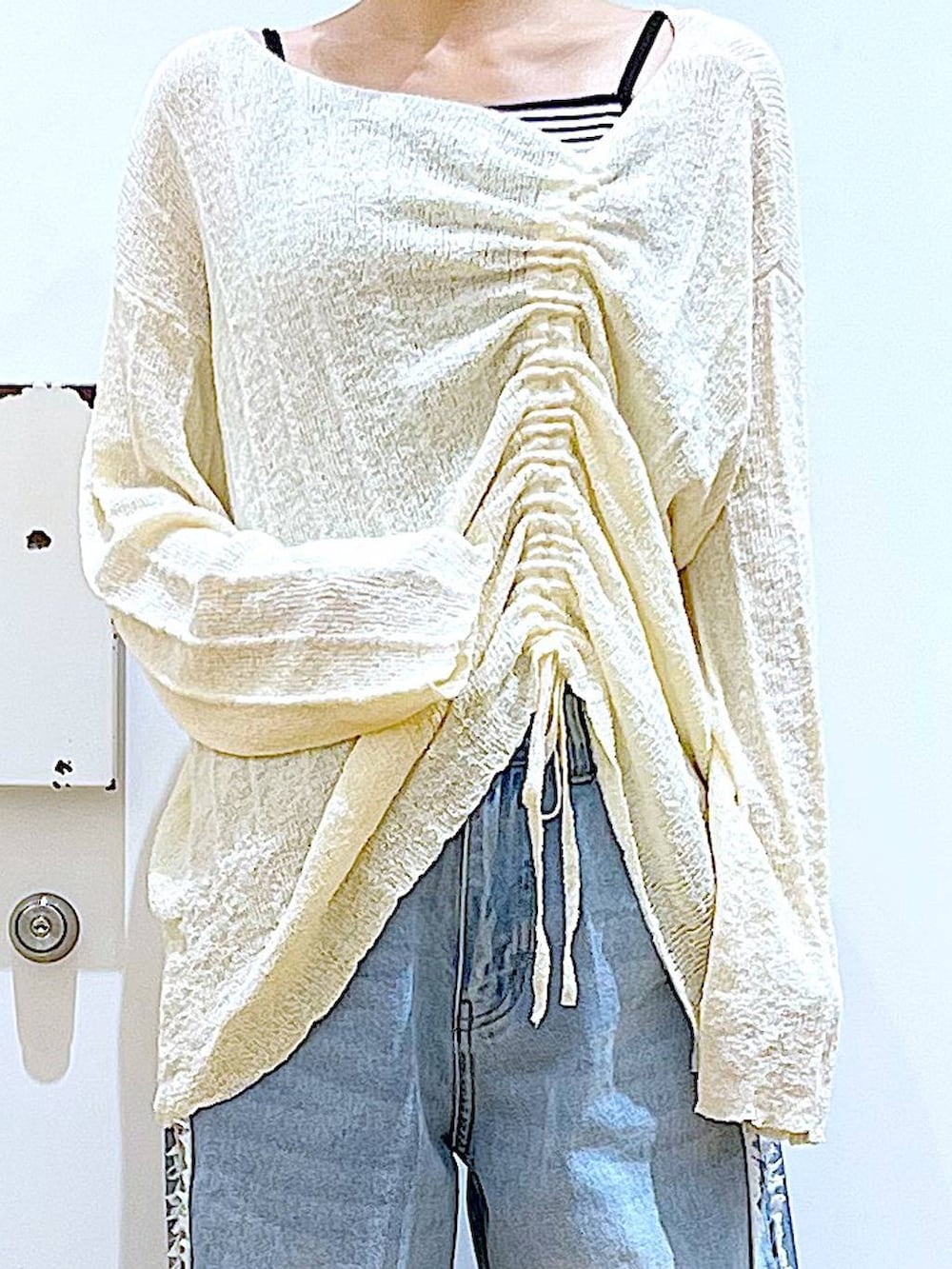 ホワイト系のショルダーバッグ、ホワイト系のパンプス、ブルー系のデニムパンツを着用したレディースの春コーディネートの7枚目の写真