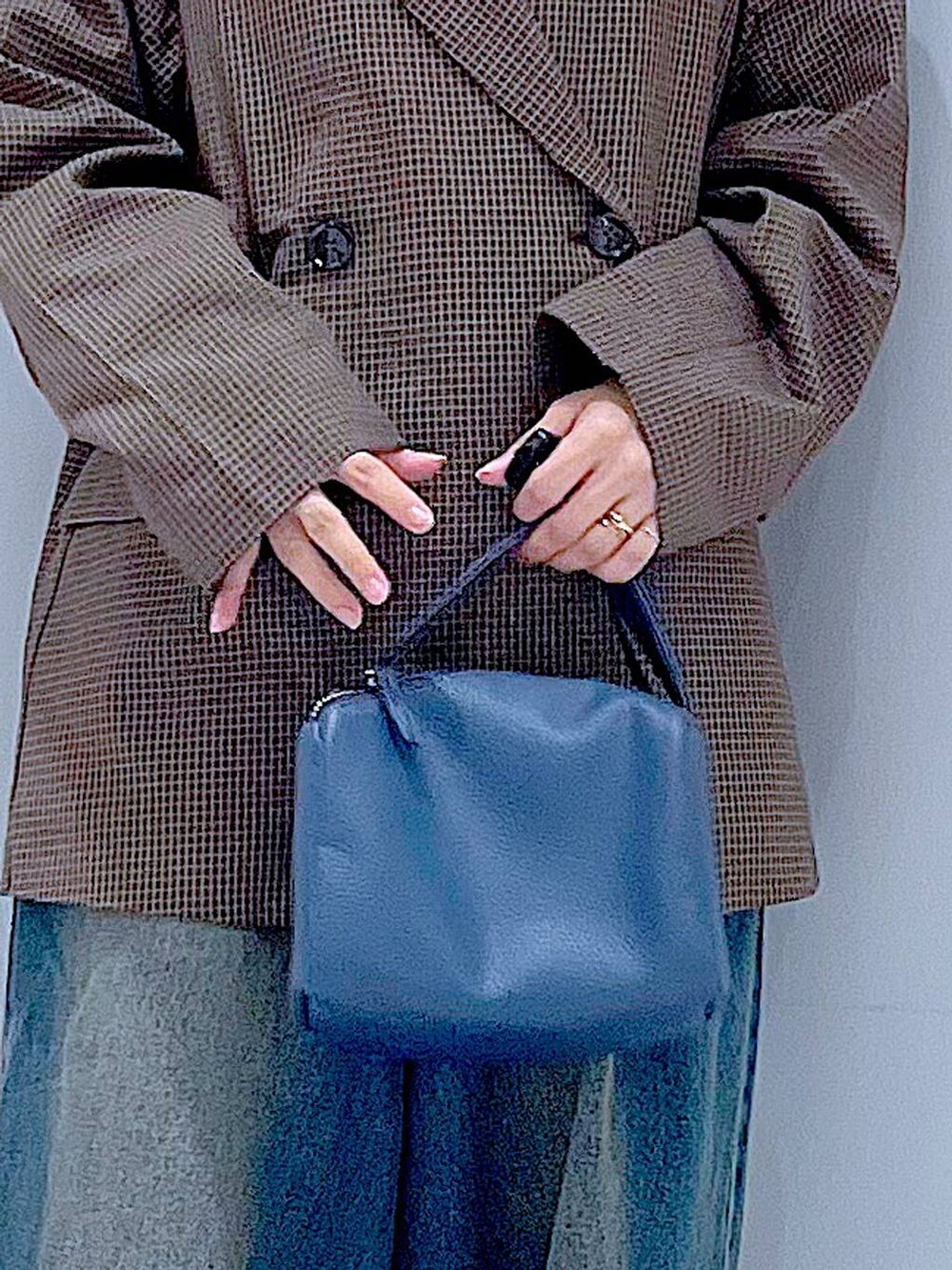 ブラック系のローファー、ブルー系のショルダーバッグ、ブルー系のデニムパンツを着用したレディースの秋コーディネートの9枚目の写真