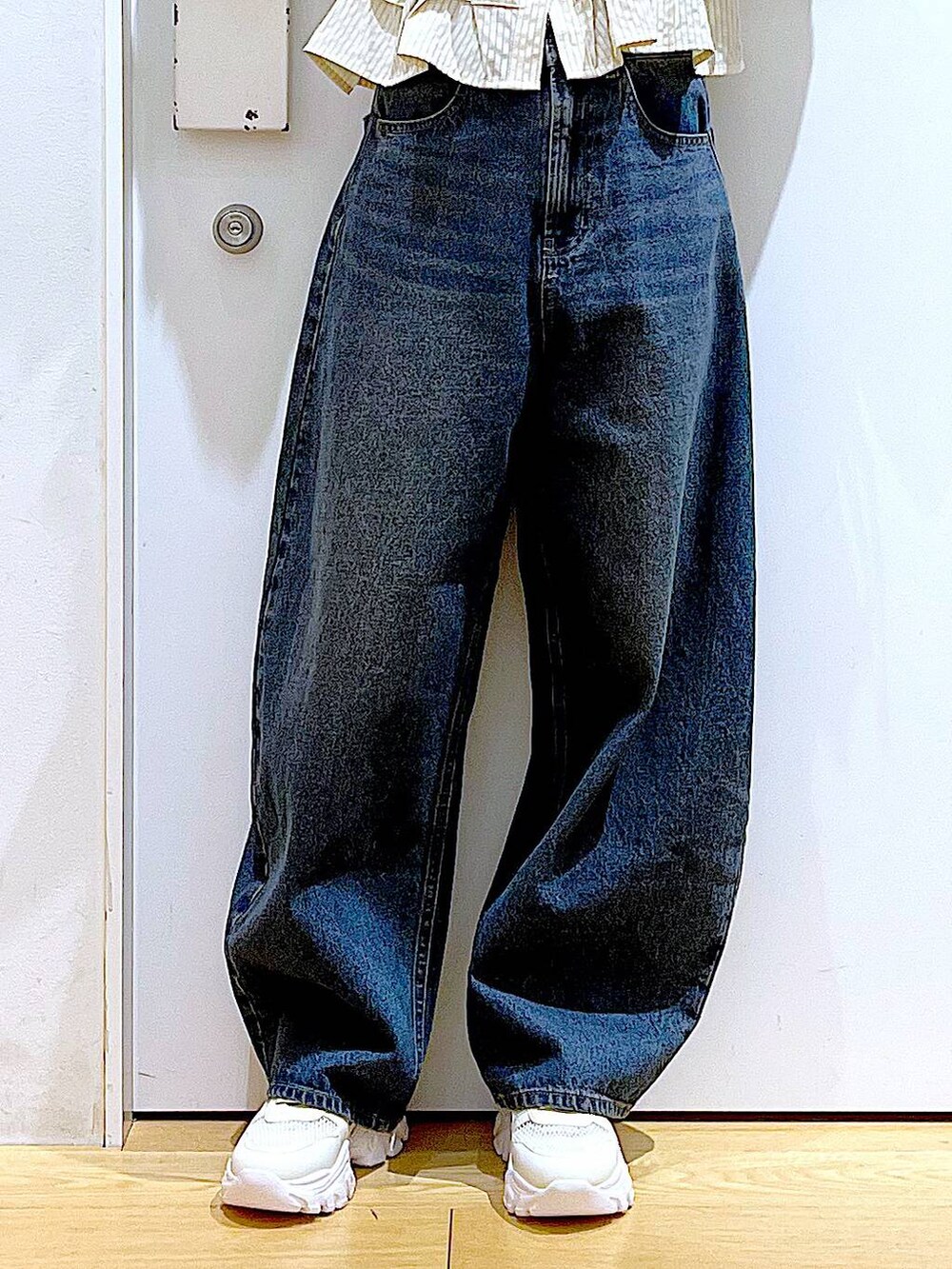 グレー系のショルダーバッグ、ブルー系のデニムパンツ、ホワイト系のスニーカーを着用したレディースの春コーディネートの8枚目の写真