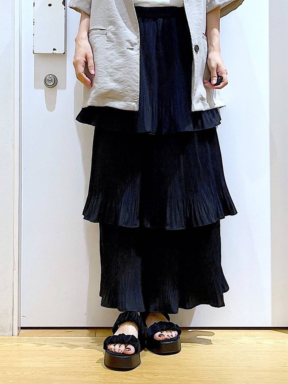 ブラック系のスカート、ブラック系のサンダル、ブラウン系のショルダーバッグを着用したレディースの夏コーディネートの8枚目の写真