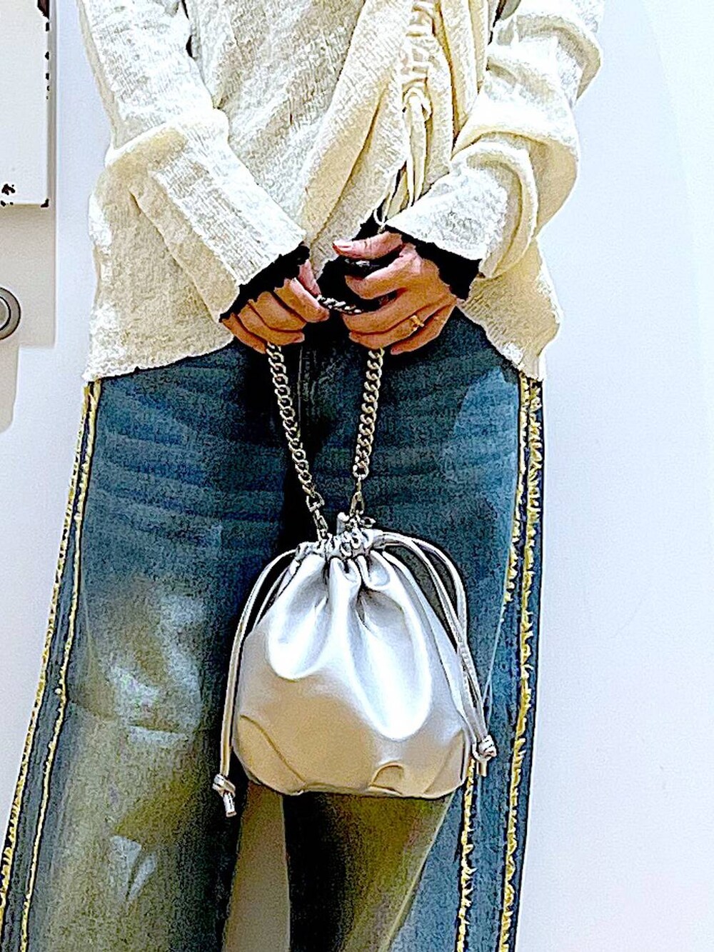 ブラック系のTシャツ/カットソー、シルバー系のショルダーバッグ、ブラック系のスニーカーを着用したレディースの春コーディネートの9枚目の写真