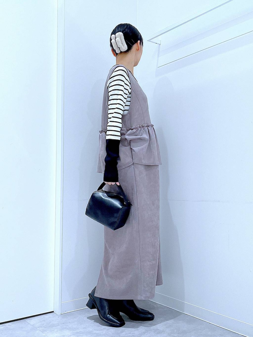 ブラック系のブーツ、グレー系のワンピース、ブラック系のショルダーバッグを着用したレディースの冬コーディネートの4枚目の写真