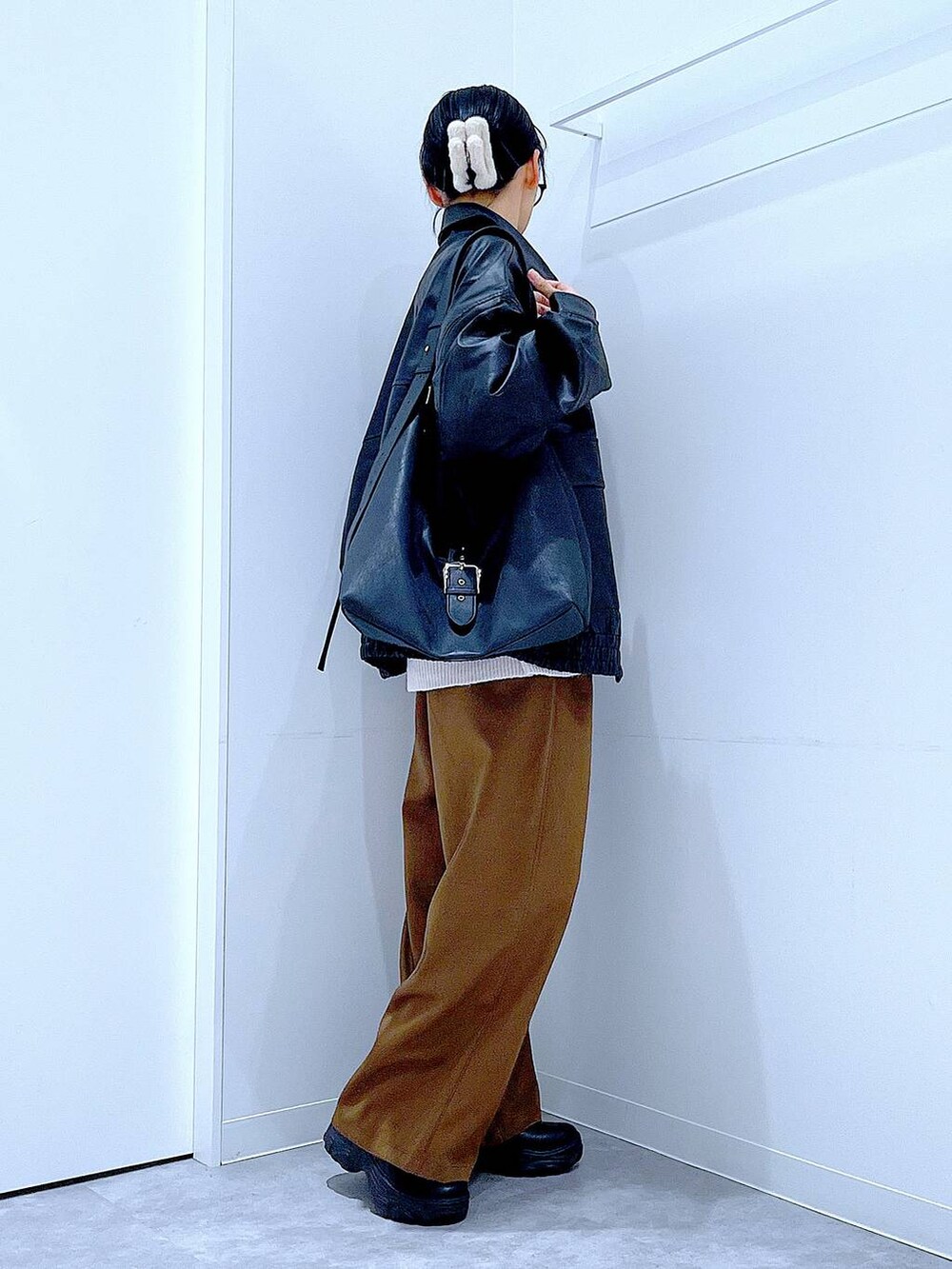 ブラック系のブルゾン、ブラック系のブーツ、ベージュ系のニット/セーターを着用したレディースの秋コーディネートの4枚目の写真