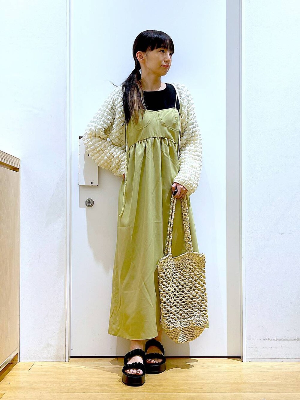 ブラック系のサンダル、ホワイト系のトートバッグ、ベージュ系のカーディガン/ボレロを着用したレディースの夏コーディネートの2枚目の写真