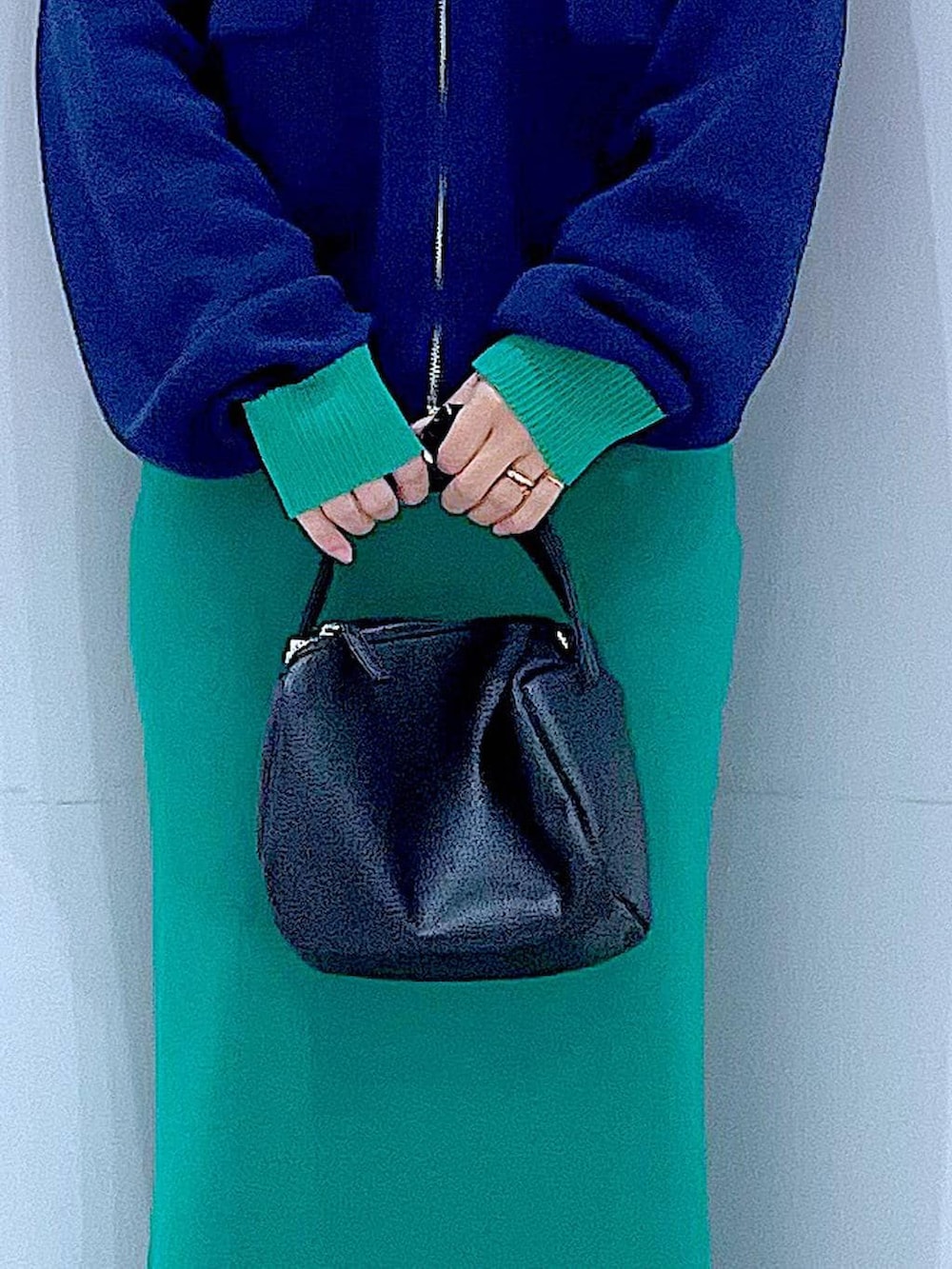 ブラック系のショルダーバッグ、ブルー系のカーディガン/ボレロ、グリーン系のスカートを着用したレディースの春コーディネートの9枚目の写真