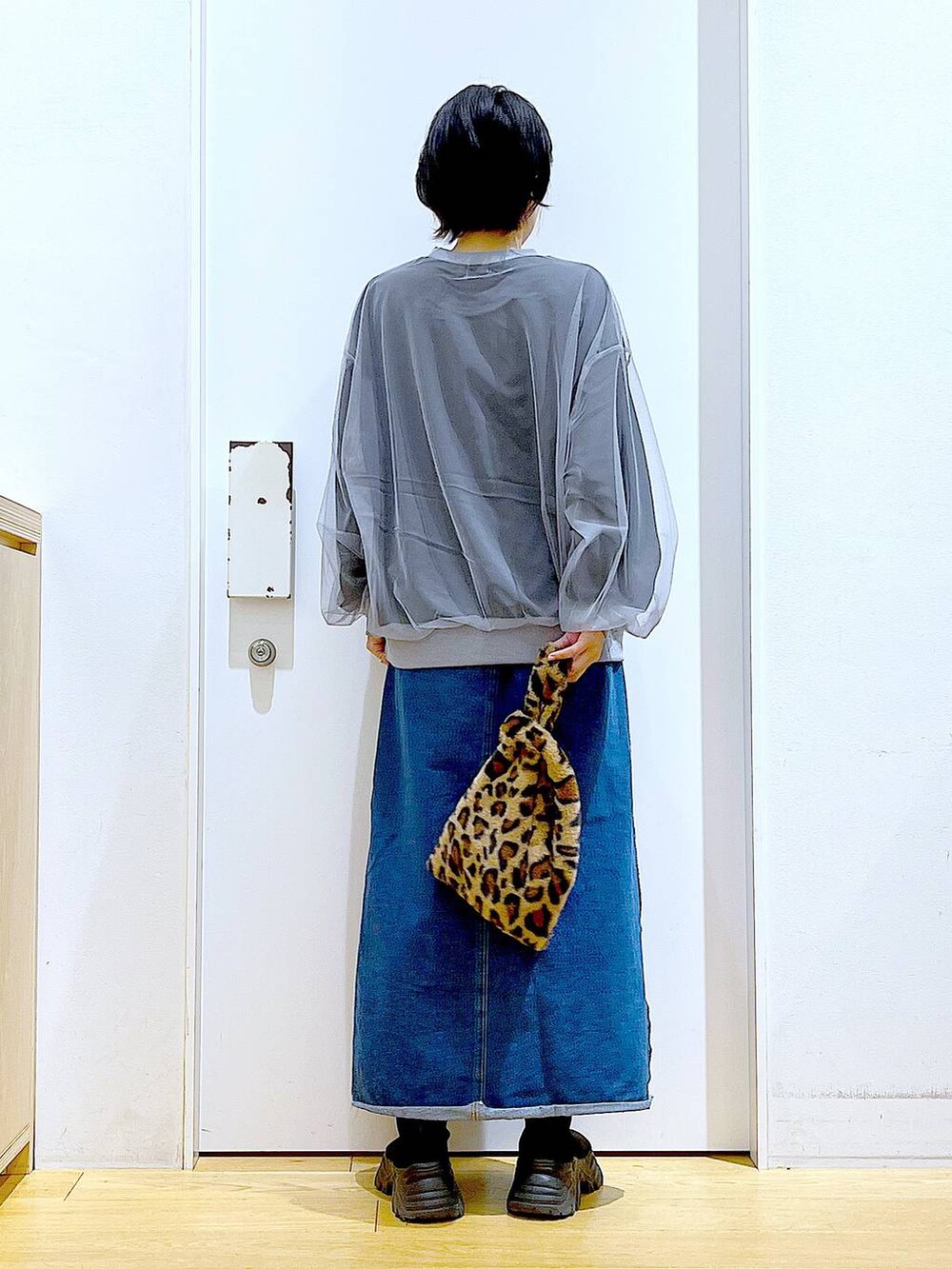 その他のショルダーバッグ、ブルー系のデニムスカート、ブラック系のブーツを着用したレディースの冬コーディネートの5枚目の写真